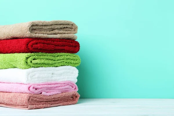 Stacked clean fluffy towels in a bathroom Stock Photo by FabrikaPhoto