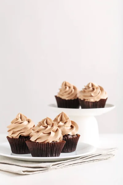 Cupcakes en plato blanco y soporte de pastel — Foto de Stock