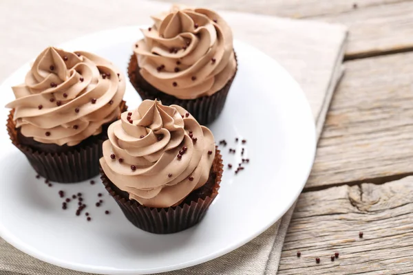 Weißer Teller mit leckeren braunen Cupcakes — Stockfoto