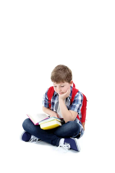 Ung pojke med böcker och ryggsäck på vit bakgrund — Stockfoto