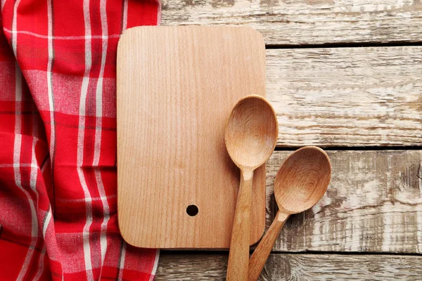 Servilleta roja con tabla de cortar y cucharas — Foto de Stock