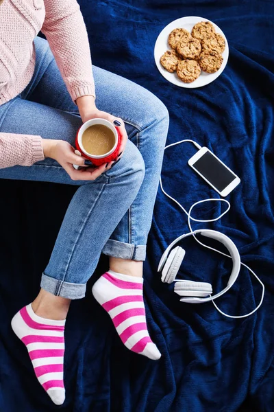 Femme avec une tasse de café assis sur plaid bleu — Photo