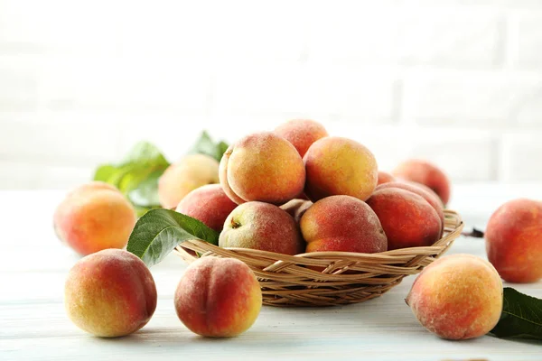 Söta persikor i korg — Stockfoto