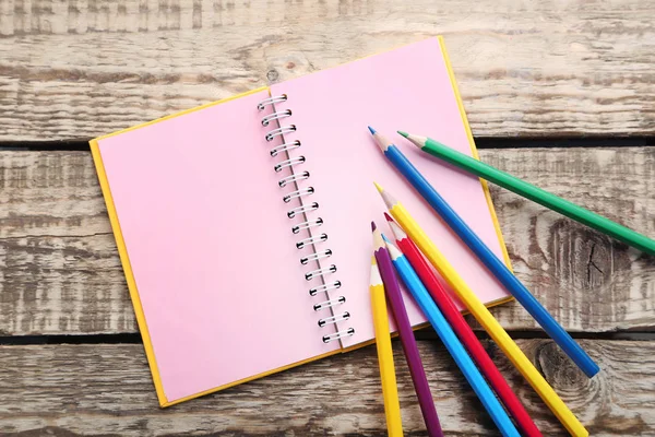 üstünde pembe sayfaları ile defter kalemler