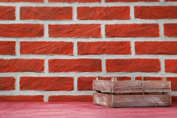 Caja de madera en el fondo de ladrillo — Foto de Stock