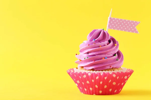 Tasty cupcake on a yellow background — Stock Photo, Image