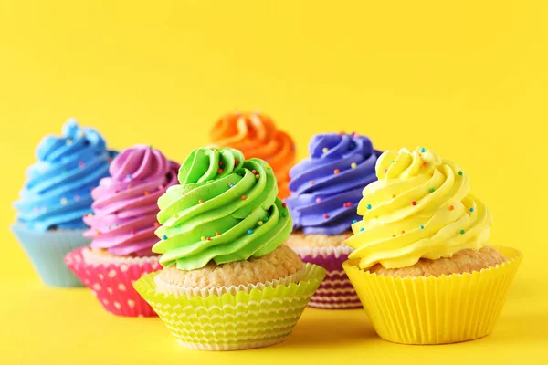 Cupcakes saborosos em um fundo amarelo — Fotografia de Stock