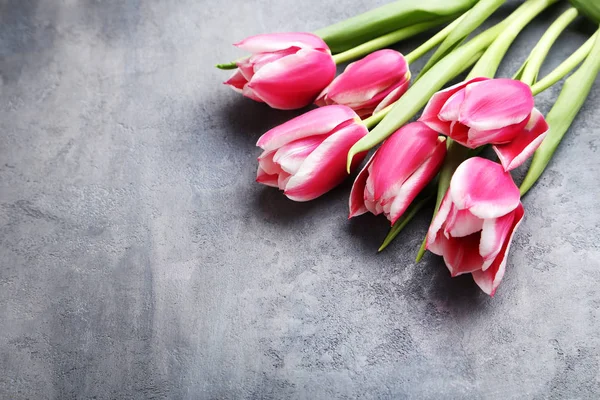 Bouquet of pink tulips on grey wooden table — Stock Photo, Image