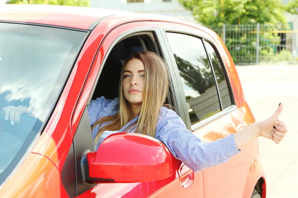 Vacker ung flicka sitter i röd bil — Stockfoto