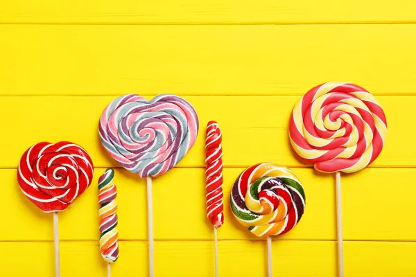 Pirulitos doces na mesa amarela — Fotografia de Stock