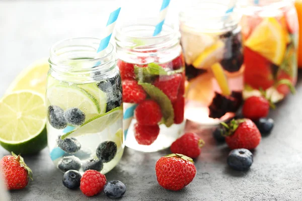 Detox water in bottles with berries — Stock Photo, Image