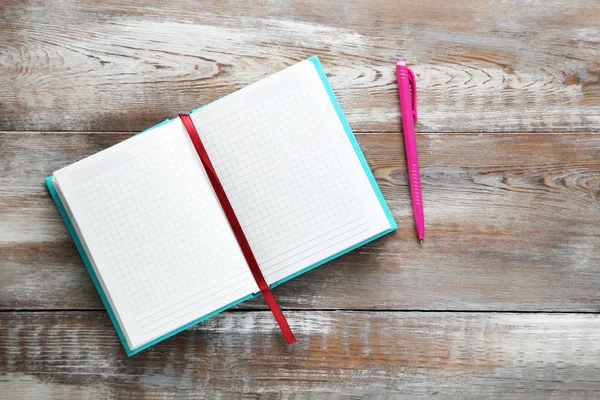 Caderno com caneta em uma mesa de madeira marrom — Fotografia de Stock