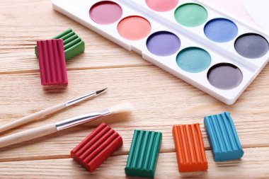 Suluboya, hamuru ve fırçalar ahşap tablo