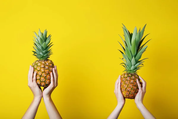 Female hands holding ripe pineapples — Stock Photo, Image