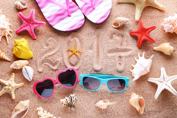 2017 dibujado en arena de playa con gafas de sol y chanclas — Foto de Stock