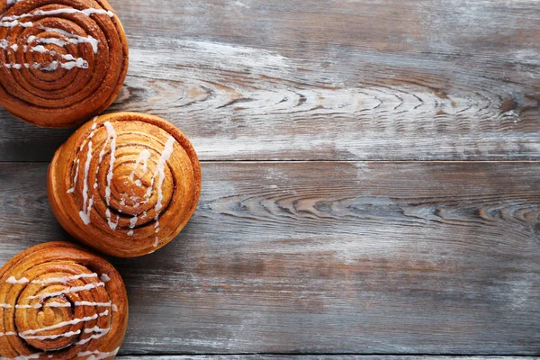 Сладкие булочки с корицей на деревянном столе — стоковое фото
