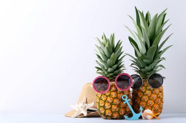 Güneş gözlüğü ve şapka ile olgun ananas