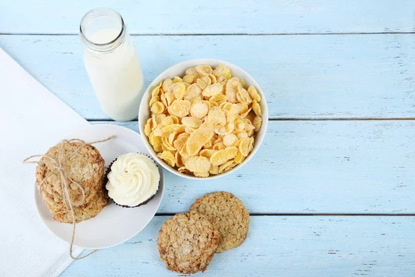 Flocons de maïs avec bouteille de lait et biscuits sur la table — Photo