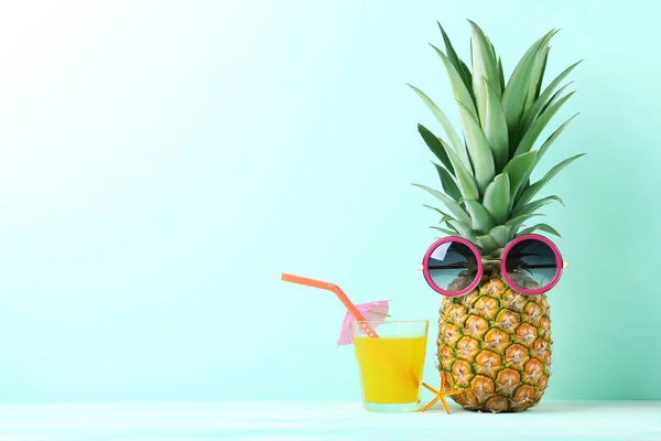 Ripe pineapple with sunglasses and glass of juice — Stock Photo, Image