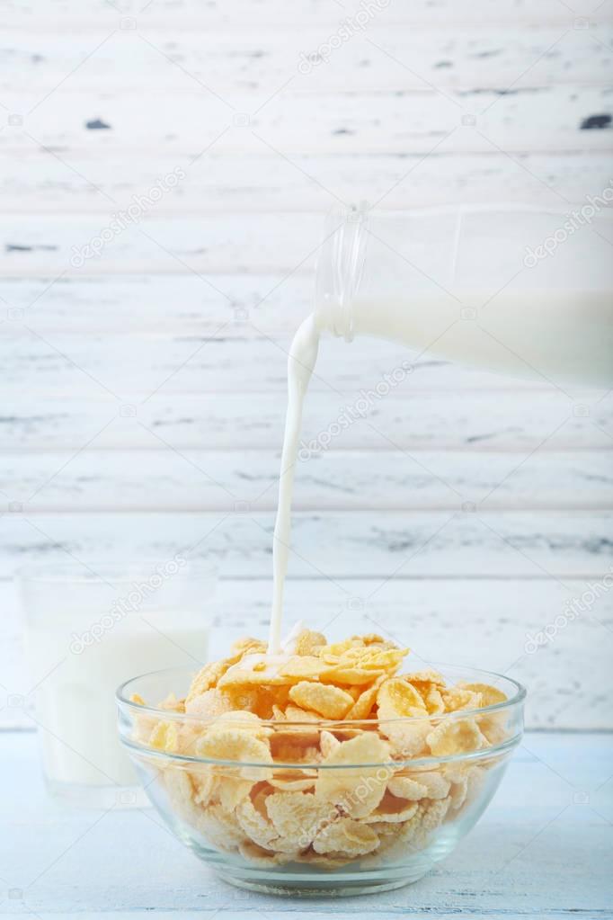 Pouring milk in bowl of cornflakes