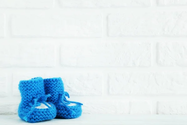 Baby booties on brick wall — Stock Photo, Image