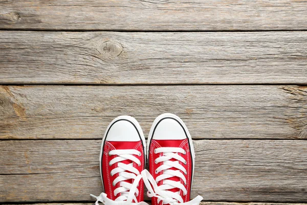 Пара червоних кросівок на дерев'яному столі — стокове фото