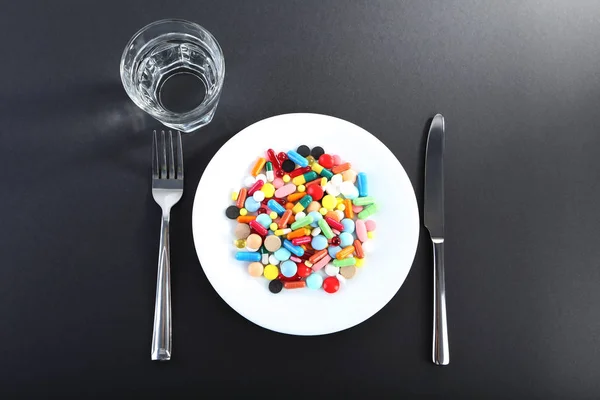 Kolorowe pigułki w biały talerz — Zdjęcie stockowe