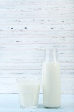 Cam ve ahşap masa üzerinde süt şişesi