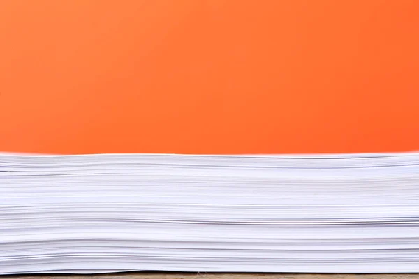 Stack of papers on orange background — Stock Photo, Image