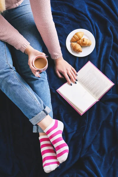 Mulher com xícara de café e livro em xadrez — Fotografia de Stock