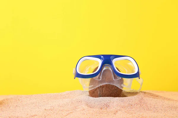 Coco inteiro em máscara de mergulho na areia — Fotografia de Stock