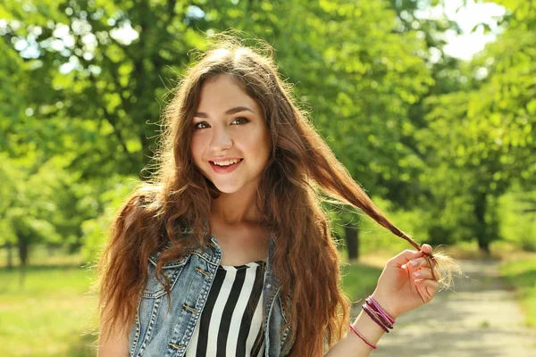 Young woman standing in park — Stock Photo, Image