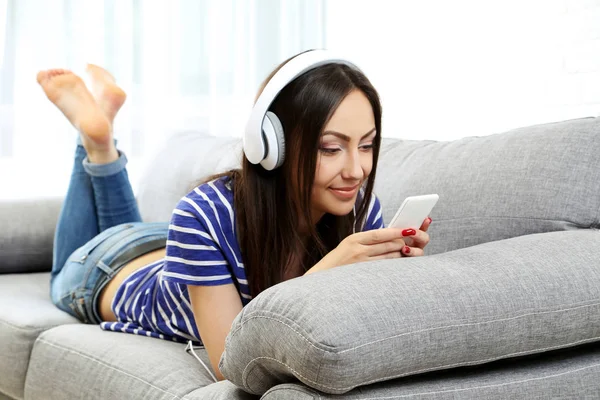 Genç bayan kanepede yatıyor. 