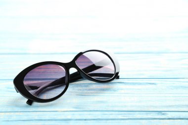 Mavi bir tablo üzerinde siyah güneş gözlüğü