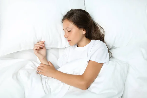 Belle fille dormant dans un lit blanc — Photo