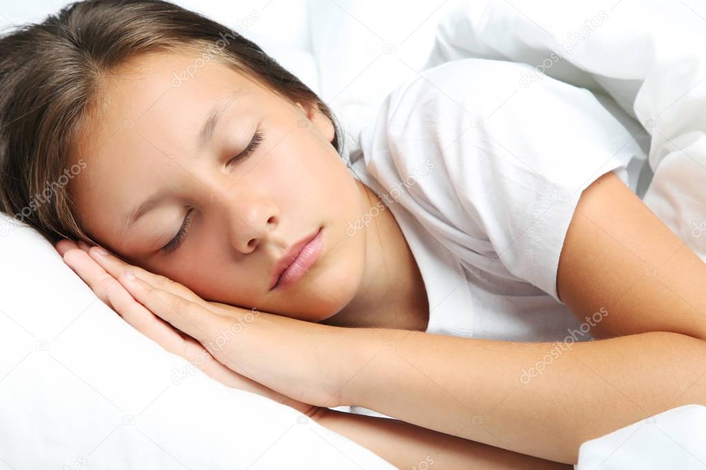 Beautiful girl sleeping in white bed