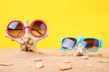 Denizyıldızı kum üzerinde güneş gözlüğü