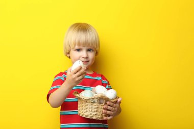 Küçük çocuk portresi Paskalya sepeti ile sarı sırtında yumurta