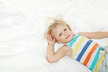 küçük çocuk beyaz yatakta yatan