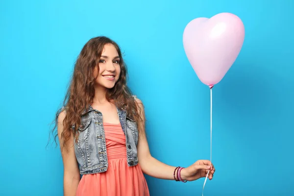Retrato de mulher jovem com balão de coração rosa em backgrou azul — Fotografia de Stock