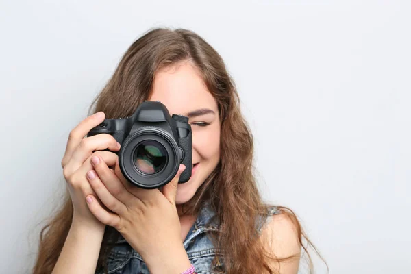 Retrato de mujer joven con cámara sobre fondo gris —  Fotos de Stock
