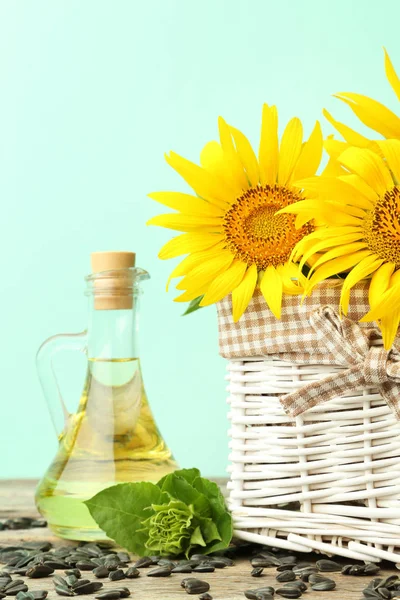 Zonnebloemen in de mand met flesje olie — Stockfoto