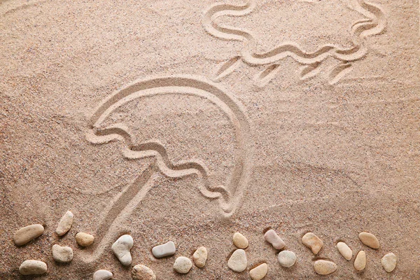 Nuvem e guarda-chuva desenhado na areia — Fotografia de Stock