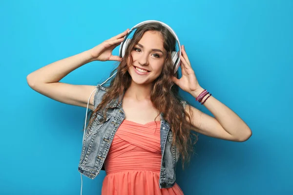 Portret van een jonge vrouw met hoofdtelefoon op blauwe achtergrond — Stockfoto