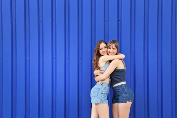 Δύο νεαρής γυναίκας που αγκαλιάζονται μεταξύ τους σε μπλε φόντο — Φωτογραφία Αρχείου