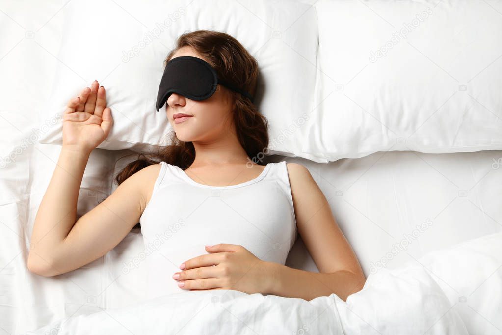 woman sleeping with eyemask in bed