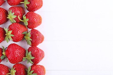 Beyaz ahşap masa üzerinde taze çilek