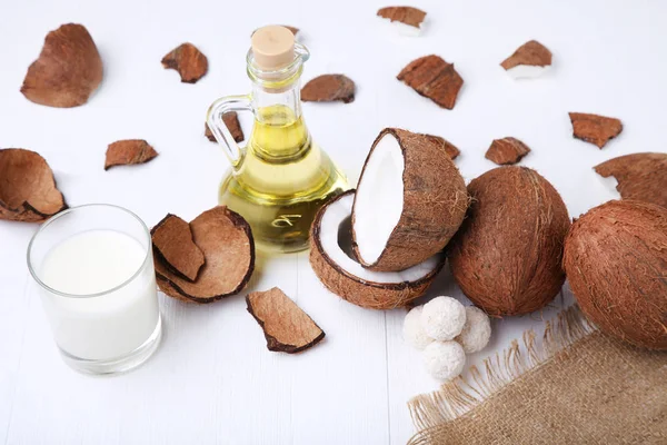 Kokosnoten met snoepjes en flesje olie — Stockfoto