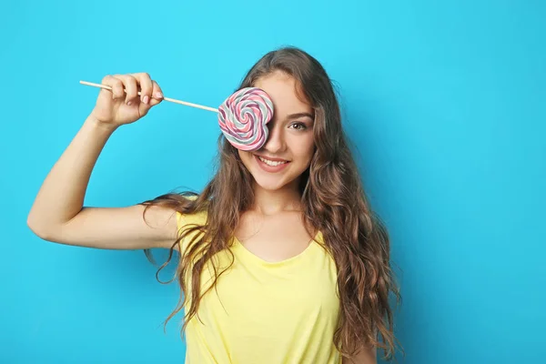 Porträtt av ung kvinna med lollipop på blå bakgrund — Stockfoto