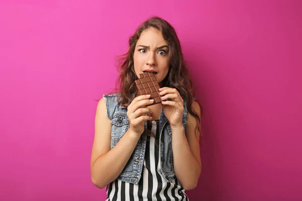 Porträt einer jungen Frau mit Schokoriegel auf rosa Hintergrund — Stockfoto